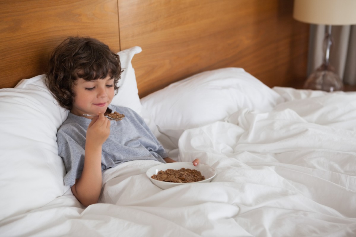 Kid eating cereal while laying in bed | Best CBSE School in Hyderabad